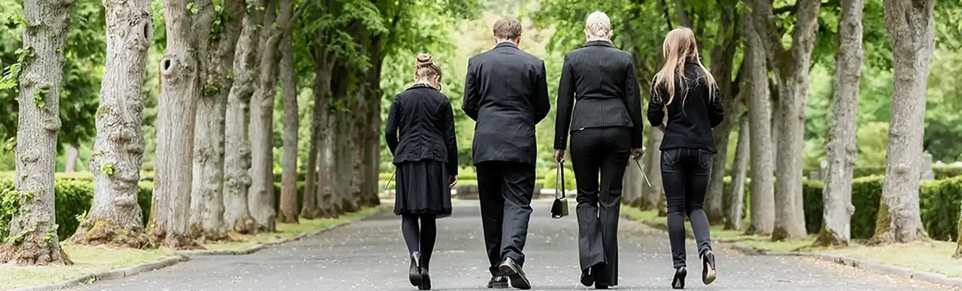 Eine junge Familie laufen auf einem Friedhof mit Trauerkleidung